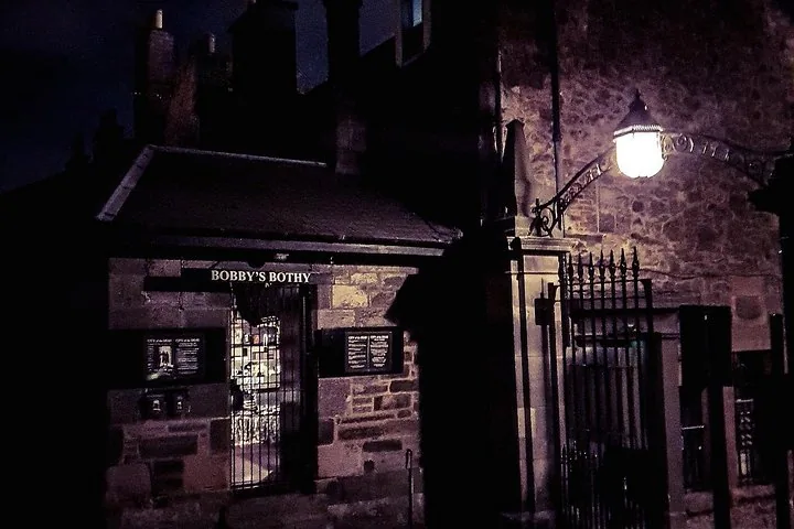 Une grille en fer à l'entrée de Greyfriars Kirkyard, la nuit.